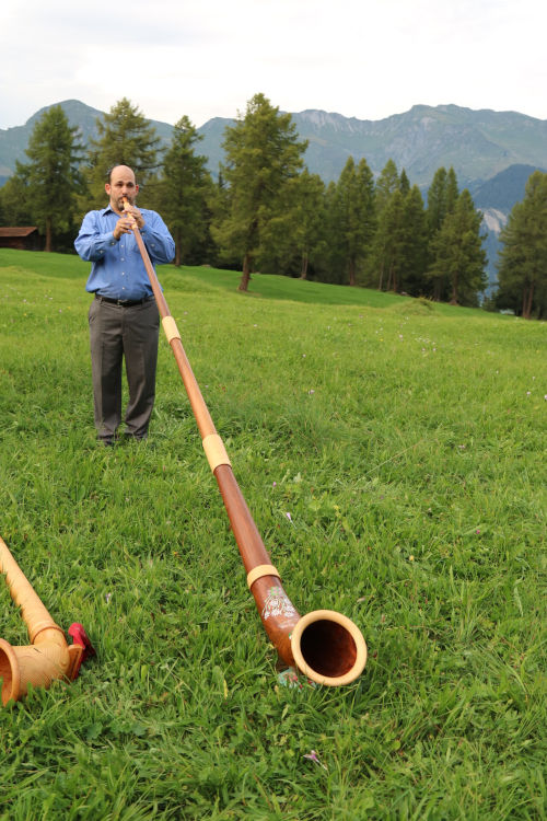 trying out an alphorn in Switzerland